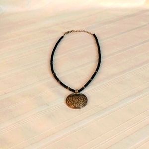 Napier black bead necklace with a small silver tone disk.